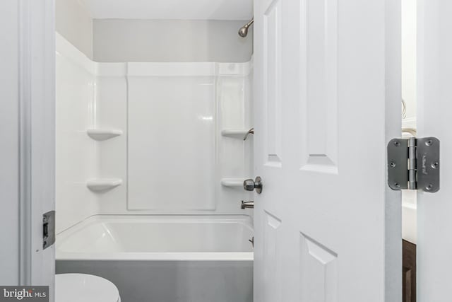 bathroom featuring washtub / shower combination and toilet