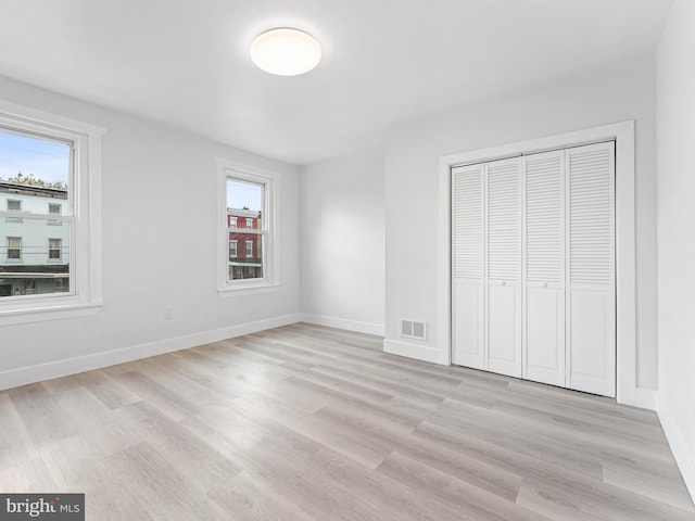 unfurnished bedroom with light hardwood / wood-style floors and a closet