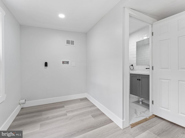 clothes washing area featuring washer hookup and light hardwood / wood-style floors