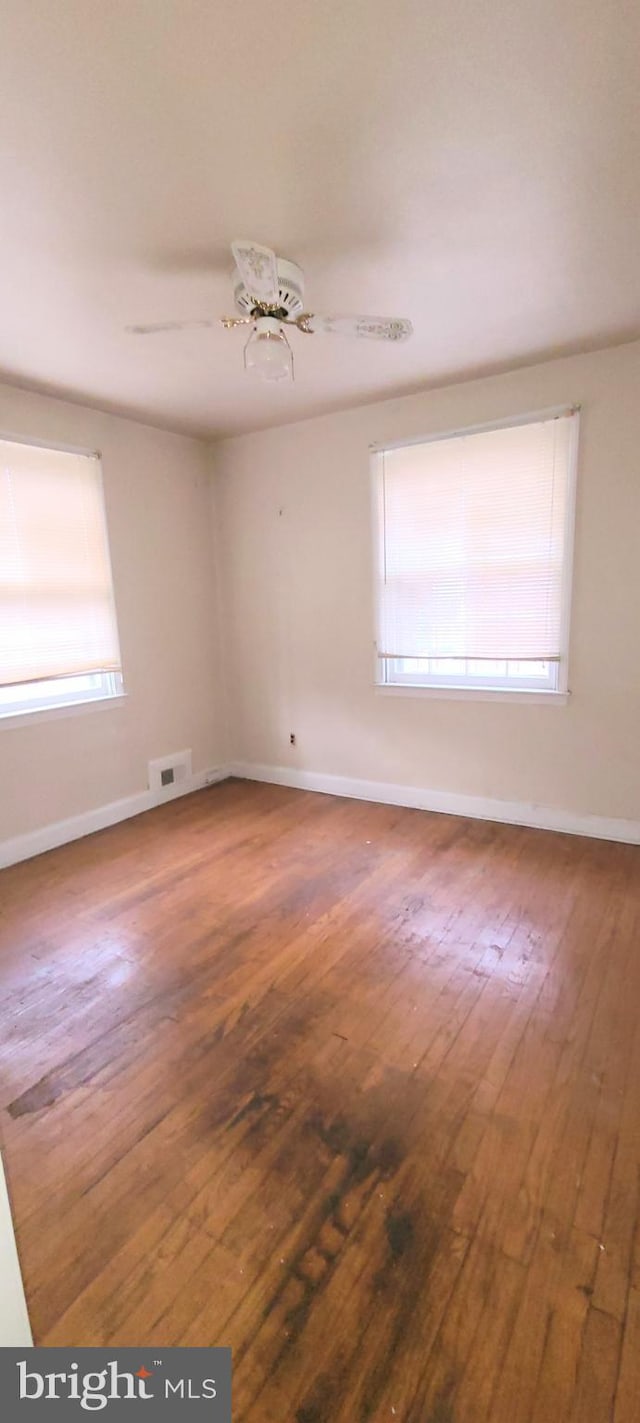 spare room featuring hardwood / wood-style floors and ceiling fan