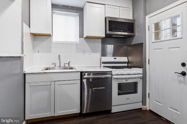 kitchen featuring sink, stainless steel appliances, tasteful backsplash, dark hardwood / wood-style flooring, and white cabinets