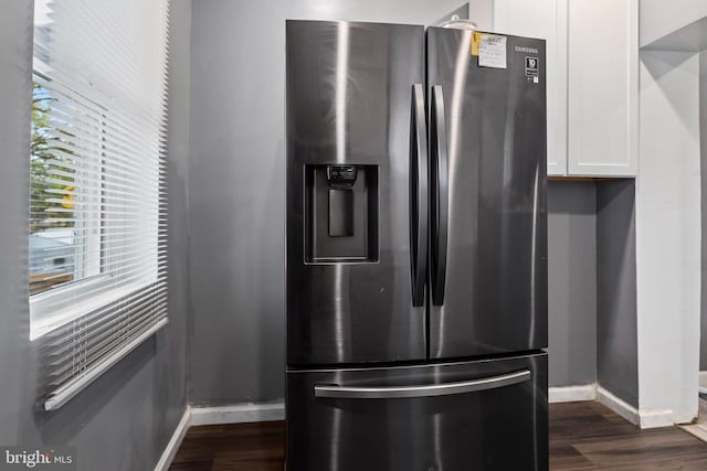 details with white cabinets, stainless steel fridge with ice dispenser, and dark wood-type flooring