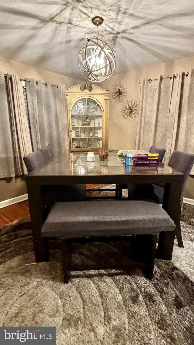 dining area with hardwood / wood-style floors and a notable chandelier