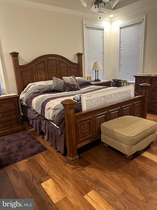 bedroom featuring hardwood / wood-style flooring, ceiling fan, and ornamental molding