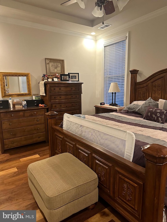 bedroom with ceiling fan, dark hardwood / wood-style flooring, and crown molding