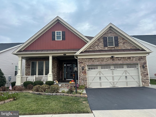 craftsman-style house with a front lawn, covered porch, and a garage