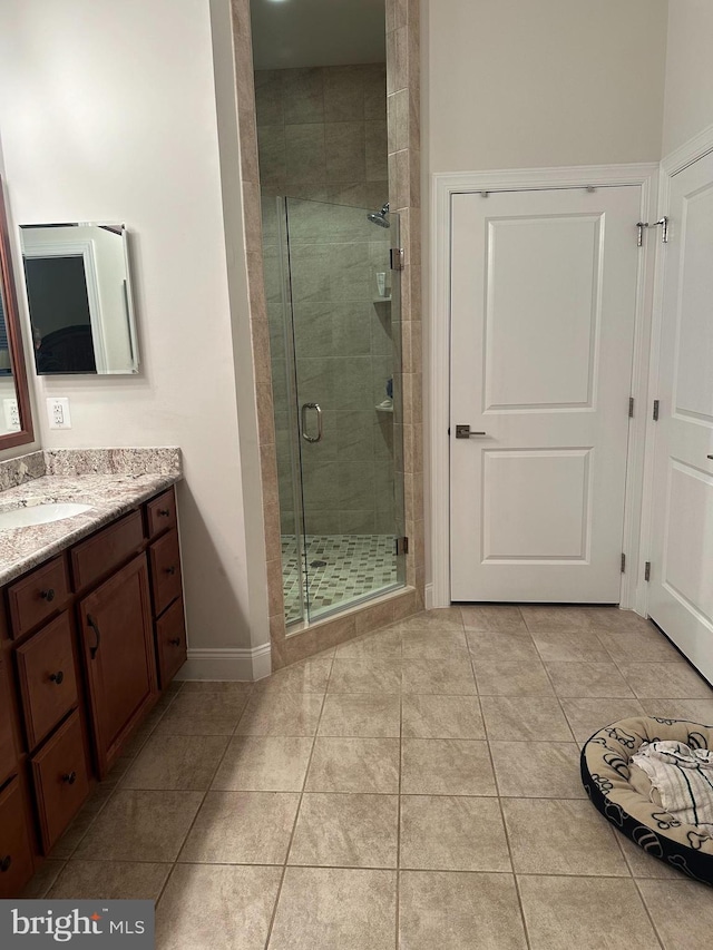 bathroom featuring tile patterned flooring, vanity, and walk in shower