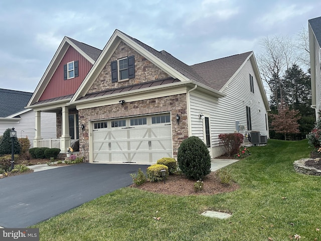 craftsman-style house with a garage, central air condition unit, and a front yard