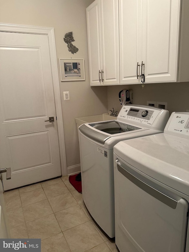 laundry area featuring cabinets, separate washer and dryer, and light tile patterned floors