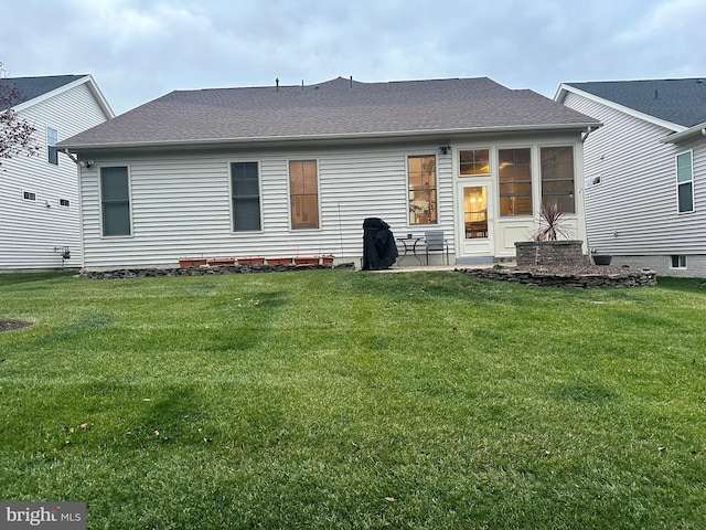 rear view of property featuring a lawn and a patio area