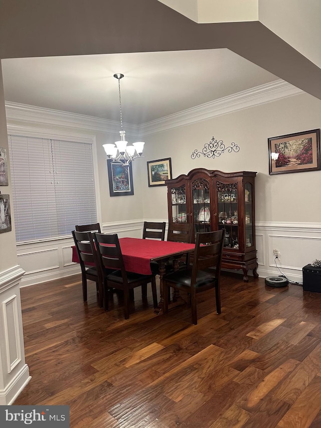 dining space featuring dark hardwood / wood-style flooring, an inviting chandelier, and ornamental molding