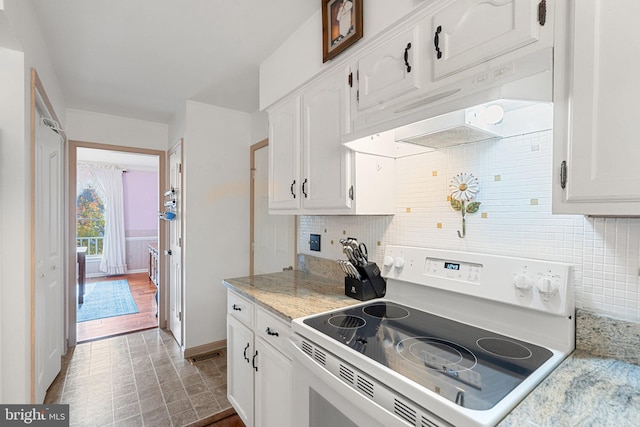 kitchen with tasteful backsplash, electric range, white cabinets, and light wood-type flooring