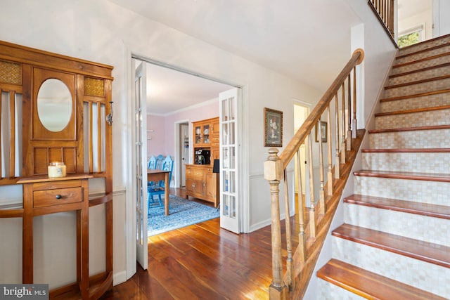stairs with french doors, hardwood / wood-style flooring, and ornamental molding