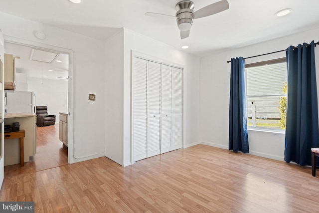 bedroom featuring white refrigerator, light hardwood / wood-style floors, a closet, and ceiling fan