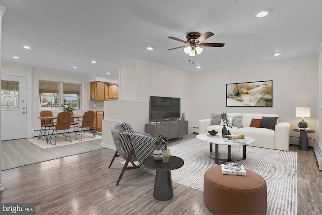 living room featuring ceiling fan, crown molding, and light wood-type flooring