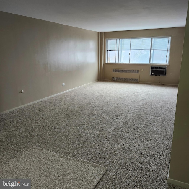 empty room with carpet, radiator heating unit, and an AC wall unit