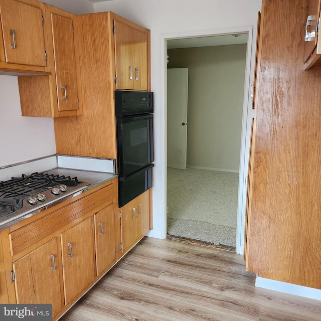 kitchen with light hardwood / wood-style floors, oven, and gas stovetop