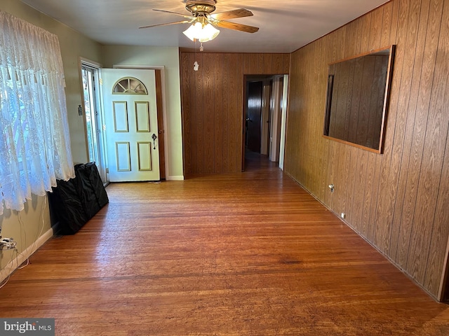 hallway with wood walls and hardwood / wood-style flooring