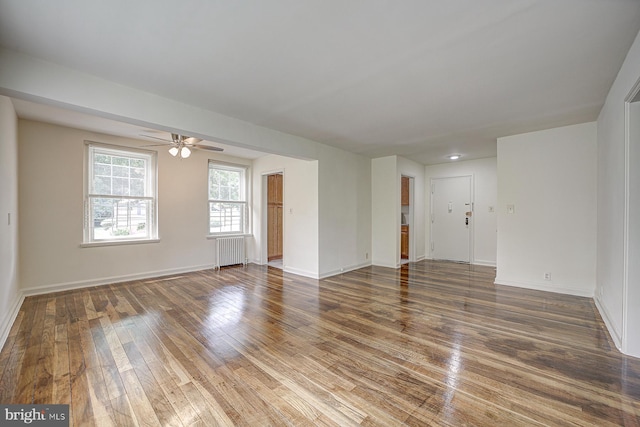 spare room featuring radiator heating unit, dark hardwood / wood-style flooring, and ceiling fan