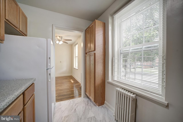 kitchen featuring ceiling fan, white refrigerator, radiator, and light hardwood / wood-style flooring