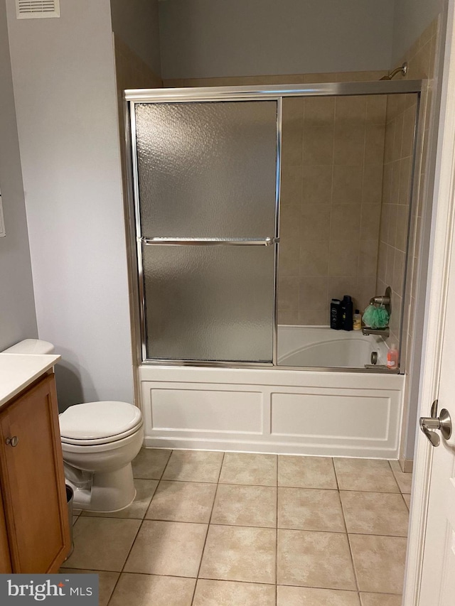 full bathroom featuring tile patterned flooring, vanity, combined bath / shower with glass door, and toilet