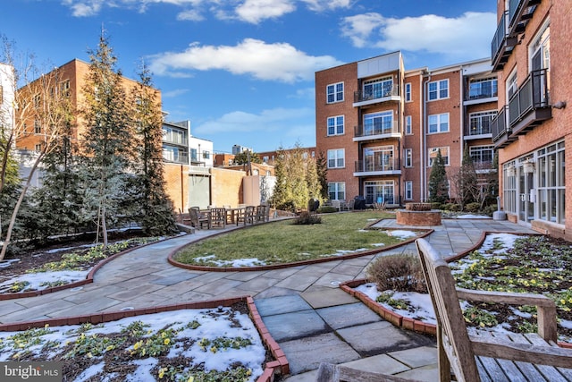 view of community featuring a lawn and a patio area