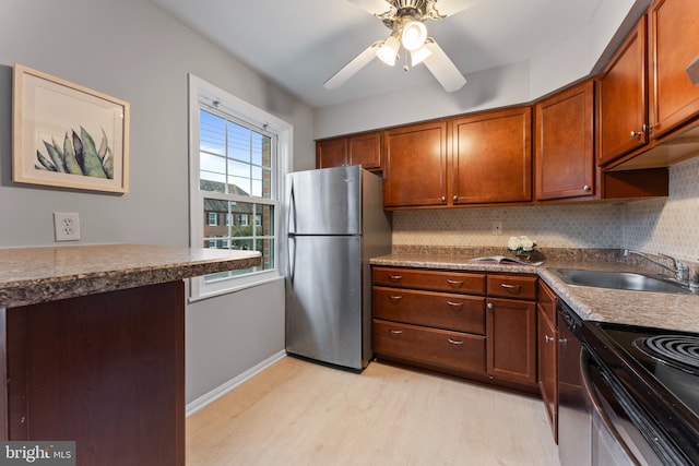 kitchen with decorative backsplash, stainless steel appliances, ceiling fan, sink, and light hardwood / wood-style floors