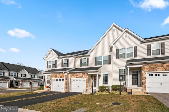 townhome / multi-family property with a front yard and a garage