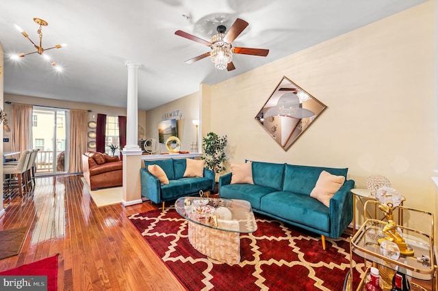 living room with wood-type flooring, decorative columns, and ceiling fan