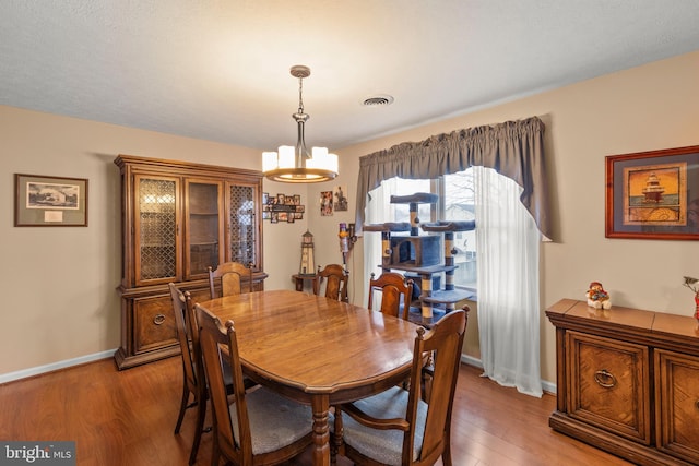 dining space featuring light hardwood / wood-style floors and an inviting chandelier