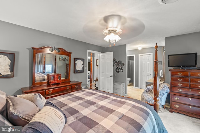 bedroom featuring ceiling fan, light carpet, and connected bathroom