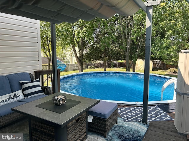 view of pool with an outdoor living space and a wooden deck