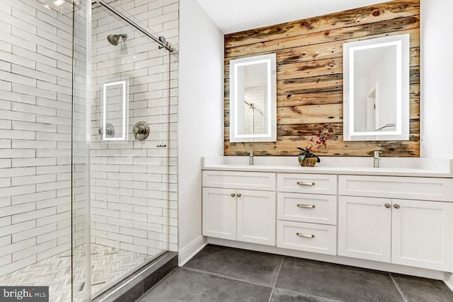 bathroom featuring tile patterned flooring, vanity, a shower with door, and wood walls