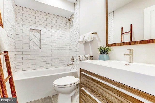 full bathroom featuring tile patterned flooring, vanity, toilet, and tiled shower / bath combo