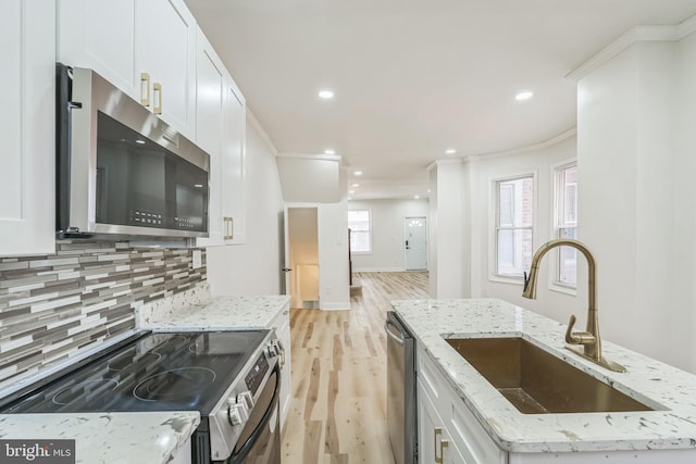 kitchen with white cabinetry, sink, light stone countertops, and appliances with stainless steel finishes