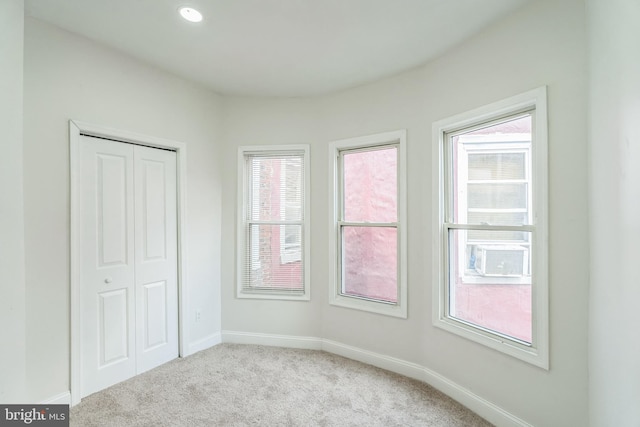 unfurnished bedroom with light carpet and a closet