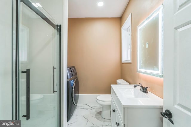 bathroom featuring vanity, a shower with door, toilet, and washing machine and dryer