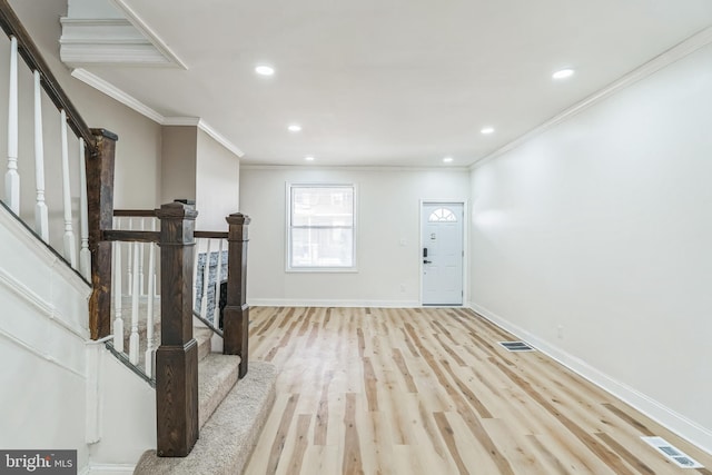 entryway with crown molding and light hardwood / wood-style flooring