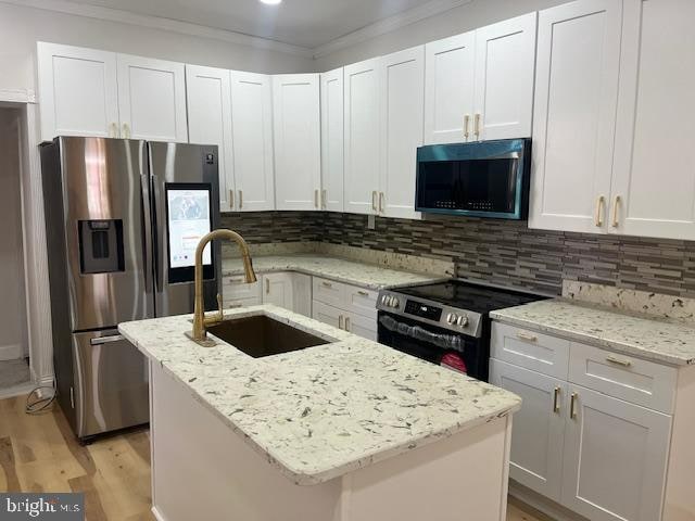 kitchen featuring a center island with sink, white cabinets, sink, and stainless steel appliances