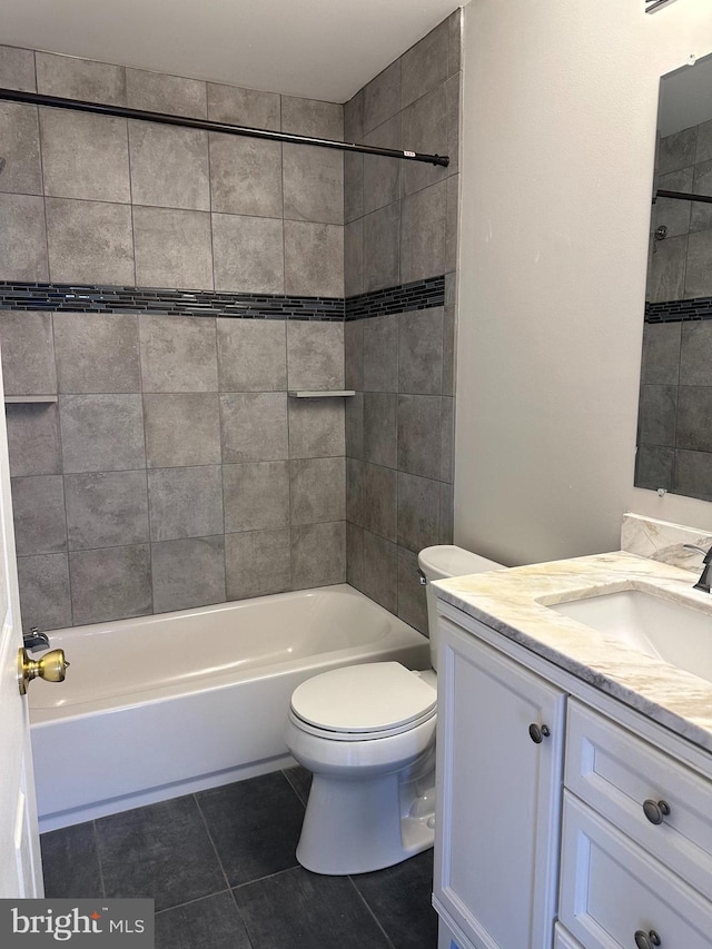 full bathroom with toilet, tile patterned floors, vanity, and tiled shower / bath combo