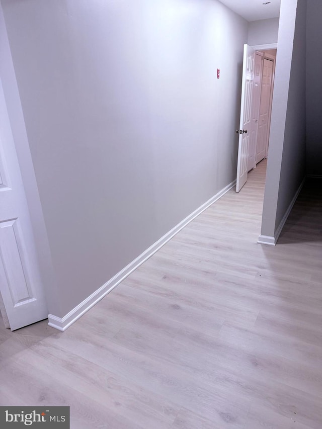 hallway with light hardwood / wood-style floors