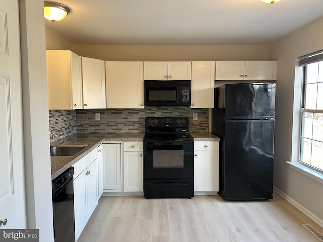 kitchen featuring black appliances, white cabinets, and light wood-type flooring