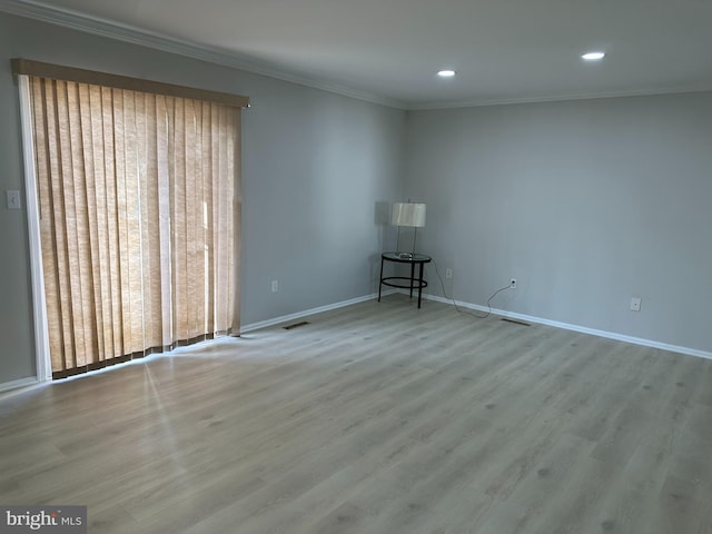 spare room with light hardwood / wood-style floors and crown molding