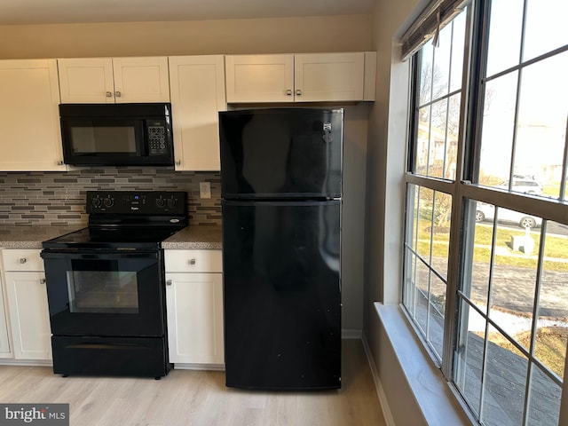 kitchen with backsplash, white cabinetry, and black appliances