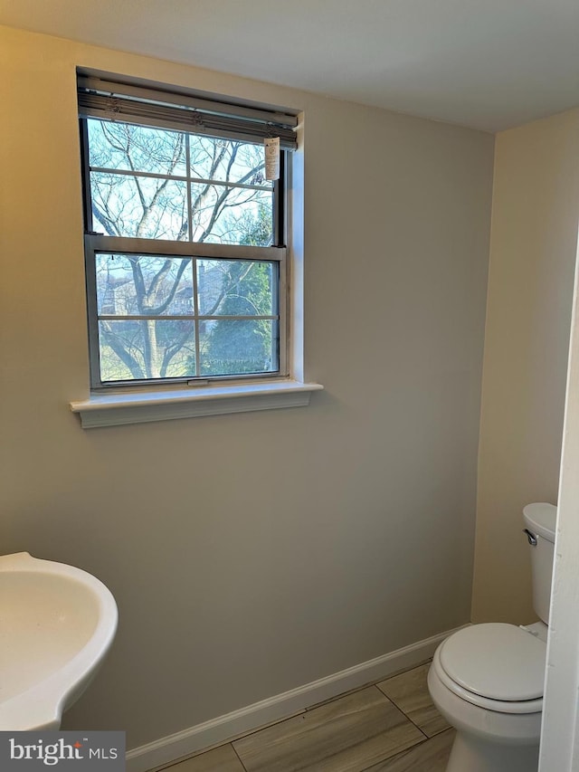 bathroom featuring toilet, wood-type flooring, and sink