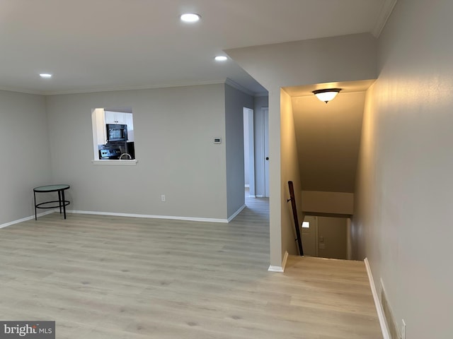 spare room featuring crown molding and light hardwood / wood-style floors