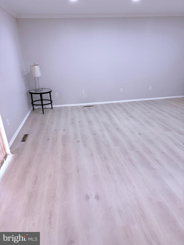 unfurnished room with crown molding and light hardwood / wood-style flooring