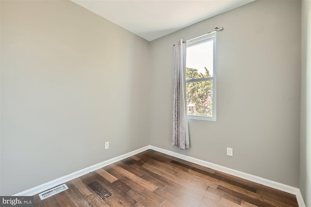 spare room with hardwood / wood-style flooring and plenty of natural light