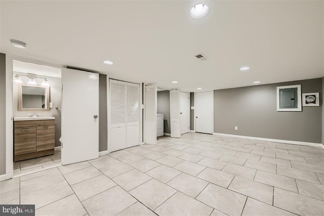 basement featuring washer / dryer, electric panel, light tile patterned floors, and sink