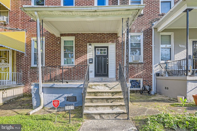 property entrance featuring cooling unit and a porch